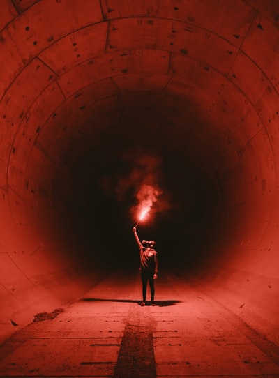 隧道内一名戴防毒面具手持火炬的男子
